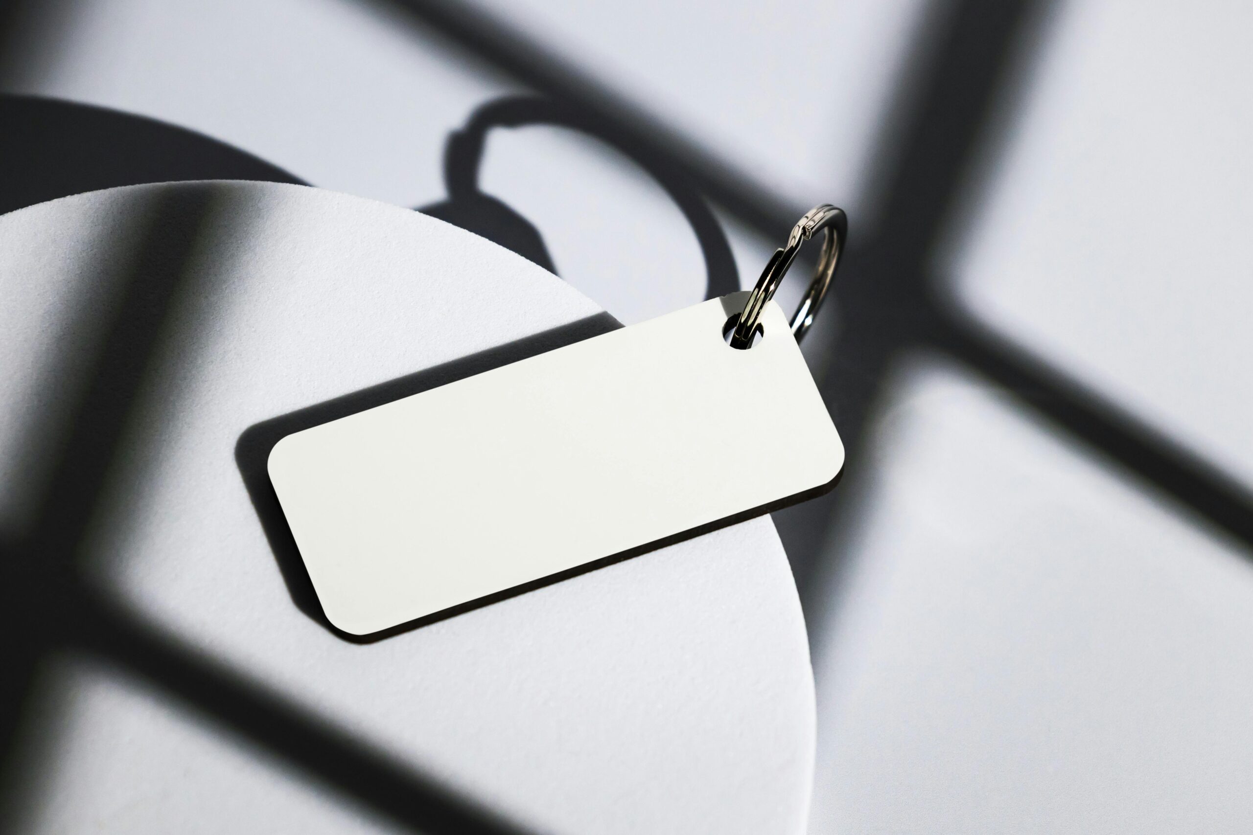 Elegant keychain on abstract shadows cast by natural light, close-up shot.